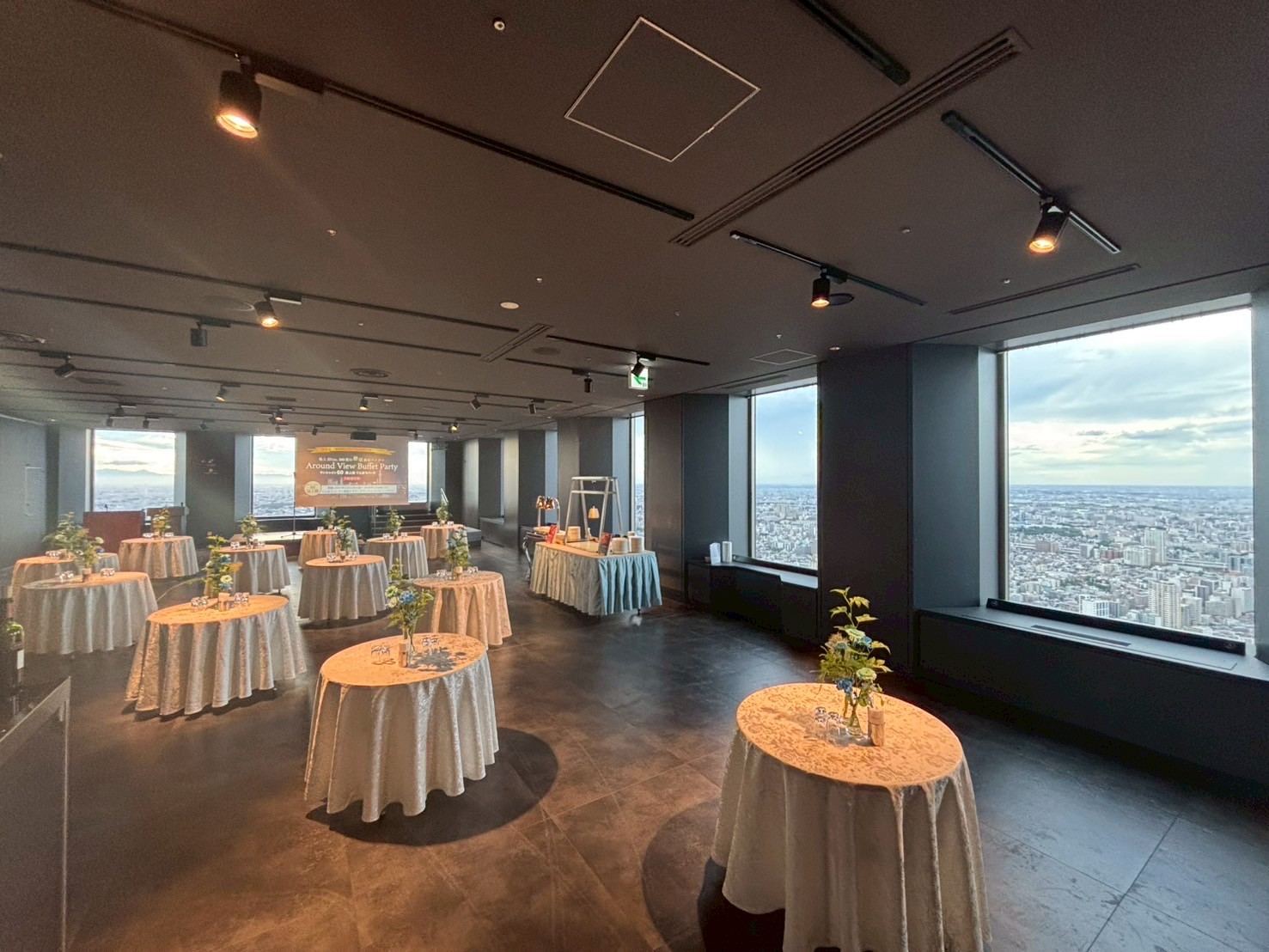 丸テーブルをセッティングしたてんぼうパークのパーティー会場。窓一面に東京の眺望が広がる。